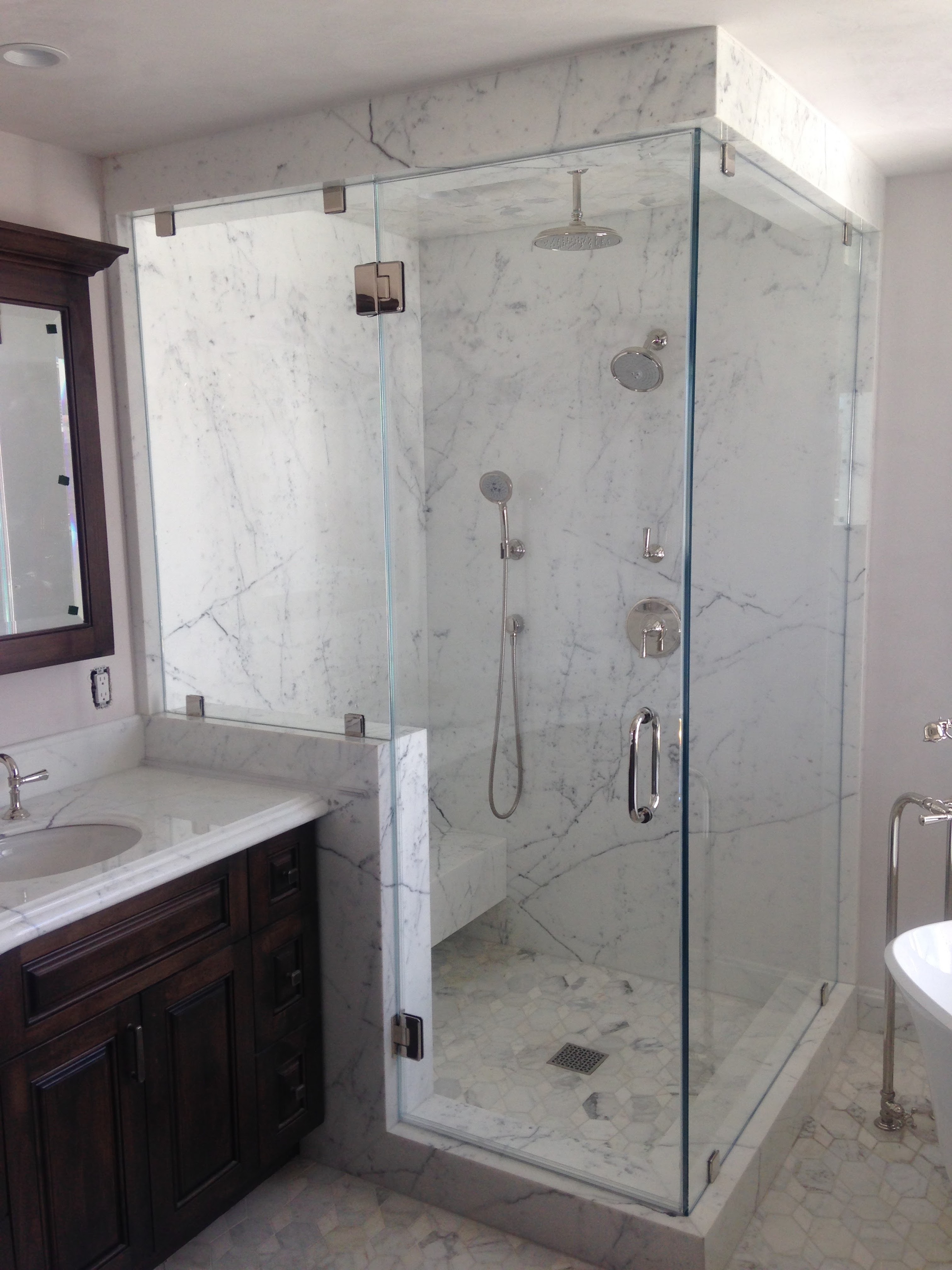 Shower door enclosure on marble bathroom.